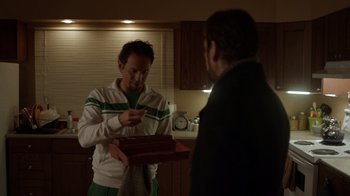Movie still from “Fargo” (2014), created by Noah Hawley – A man holding a box while another man looks at him; Medium shot, Over the shoulder angle