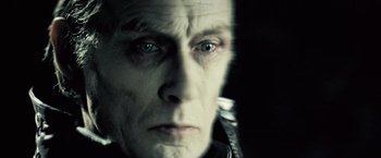 Movie still from “Underworld: Evolution” (2006), directed by Len Wiseman – An old man with a long white beard looking at the camera; Extreme Close Up shot, Over the shoulder angle