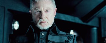 Movie still from “Underworld: Evolution” (2006), directed by Len Wiseman – An older man with white hair wearing a black jacket; Close Up shot, Over the shoulder angle