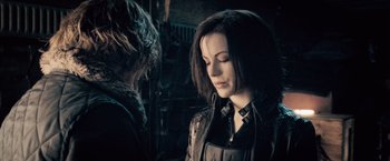 Movie still from “Underworld: Evolution” (2006), directed by Len Wiseman – A woman in a leather jacket looking down at another woman in a leather jacket; Close Up shot, Over the shoulder angle
