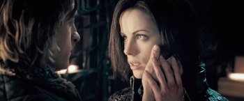 Movie still from “Underworld: Evolution” (2006), directed by Len Wiseman – A person with a hand on her face; Close Up shot, Over the shoulder angle