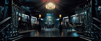 Movie still from “Underworld: Evolution” (2006), directed by Len Wiseman – A man sitting at a piano in a dark room with chandeliers; Wide shot, High angle