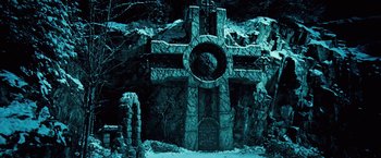 Movie still from “Underworld: Evolution” (2006), directed by Len Wiseman – A stone cross with a clock on it in the middle of the night; Wide shot, High angle