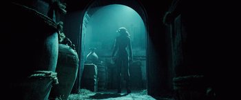 Movie still from “Underworld: Evolution” (2006), directed by Len Wiseman – A woman standing in a doorway in a dark room; Wide shot, Low angle