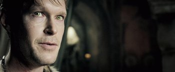 Movie still from “Underworld: Evolution” (2006), directed by Len Wiseman – A person's face in a dark room; Close Up shot, Over the shoulder angle