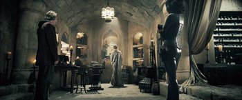 Movie still from “Underworld: Evolution” (2006), directed by Len Wiseman – A woman standing in a room filled with furniture; Wide shot, High angle