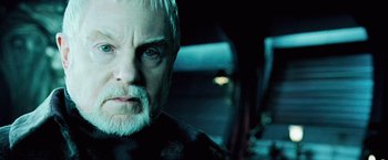 Movie still from “Underworld: Evolution” (2006), directed by Len Wiseman – An older man with white hair stares into the camera; Close Up shot, Over the shoulder angle