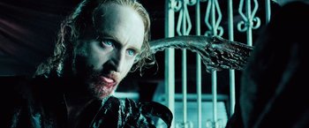 Movie still from “Underworld: Evolution” (2006), directed by Len Wiseman – A person with a beard and blue eyes; Close Up shot, Over the shoulder angle