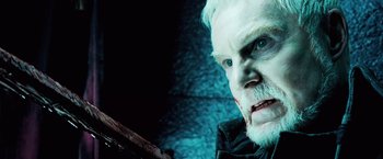 Movie still from “Underworld: Evolution” (2006), directed by Len Wiseman – An old man with a white beard is looking at the camera; Close Up shot, Low angle