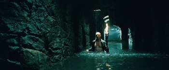 Movie still from “Underworld: Evolution” (2006), directed by Len Wiseman – A man in a body of water holding a wrench; Wide shot, High angle
