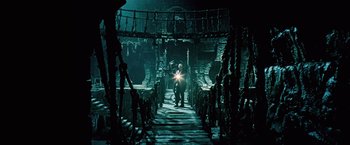 Movie still from “Underworld: Evolution” (2006), directed by Len Wiseman – A man standing on a staircase in a dark room; Wide shot, High angle