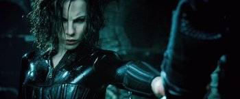 Movie still from “Underworld: Evolution” (2006), directed by Len Wiseman – A person holding a gun in a dark place; Close Up shot, Low angle