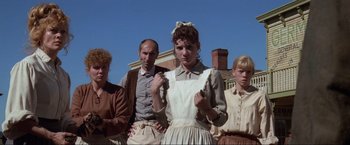 Movie still from “Unforgiven” (1992), directed by Clint Eastwood – A group of people standing next to each other in front of a building; Medium shot, Low angle