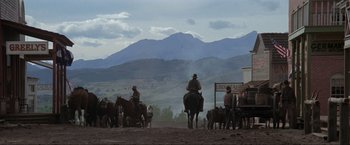 Movie still from “Unforgiven” (1992), directed by Clint Eastwood – A group of men on horses on a dirt road; Extreme Wide shot, Low angle
