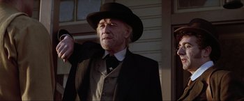 Movie still from “Unforgiven” (1992), directed by Clint Eastwood – An older man in a suit and hat; Close Up shot, Low angle