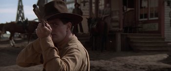 Movie still from “Unforgiven” (1992), directed by Clint Eastwood – A man in a hat and a brown jacket; Close Up shot, Low angle