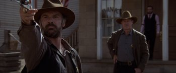 Movie still from “Unforgiven” (1992), directed by Clint Eastwood – A man in a brown hat and a man in a brown jacket; Medium shot, Low angle