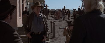 Movie still from “Unforgiven” (1992), directed by Clint Eastwood – A group of people in a field with a gun; Medium shot, Over the shoulder angle
