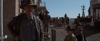 Movie still from “Unforgiven” (1992), directed by Clint Eastwood – A group of men standing next to each other on a dirt road; Medium shot, Low angle