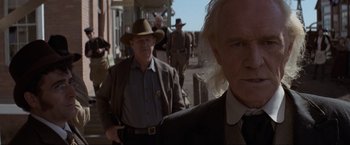 Movie still from “Unforgiven” (1992), directed by Clint Eastwood – A group of men walking down a street; Close Up shot, Low angle