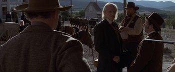Movie still from “Unforgiven” (1992), directed by Clint Eastwood – A group of people standing around a herd of horses; Medium shot, Over the shoulder angle