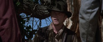 Movie still from “Unforgiven” (1992), directed by Clint Eastwood – A man wearing a hat standing next to a tree; Close Up shot, Low angle