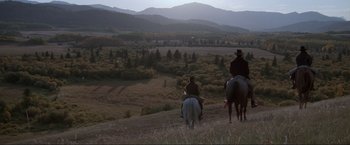 Movie still from “Unforgiven” (1992), directed by Clint Eastwood – Two people riding horses on a grassy hill; Extreme Wide shot, High angle