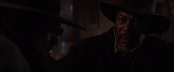 Movie still from “Unforgiven” (1992), directed by Clint Eastwood – A man in a cowboy hat is looking into the distance; Close Up shot, Over the shoulder angle