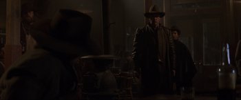 Movie still from “Unforgiven” (1992), directed by Clint Eastwood – A man wearing a hat and a coat; Medium shot, Low angle