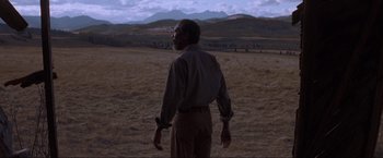 Movie still from “Unforgiven” (1992), directed by Clint Eastwood – A man standing in the middle of an open field; Wide shot, Low angle