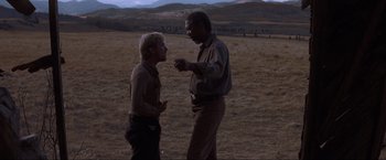 Movie still from “Unforgiven” (1992), directed by Clint Eastwood – Two men talking in an open field at night; Medium shot, Over the shoulder angle