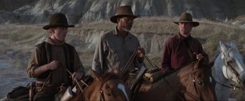 Movie still from “Unforgiven” (1992), directed by Clint Eastwood – A man on a horse with a hat on; Medium shot, Over the shoulder angle