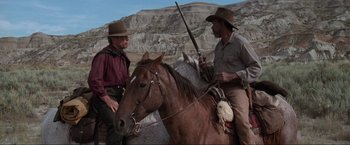 Movie still from “Unforgiven” (1992), directed by Clint Eastwood – Two men on horses with guns in their hands; Medium shot, Over the shoulder angle