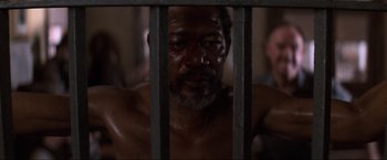 Movie still from “Unforgiven” (1992), directed by Clint Eastwood – A person behind a fence; Close Up shot, High angle