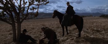 Movie still from “Unforgiven” (1992), directed by Clint Eastwood – A man on a horse and a woman on a horse in a field; Wide shot, High angle