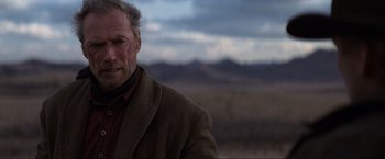 Movie still from “Unforgiven” (1992), directed by Clint Eastwood – A person wearing a jacket; Close Up shot, Low angle