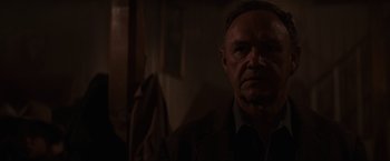 Movie still from “Unforgiven” (1992), directed by Clint Eastwood – A person wearing a suit and tie; Close Up shot, Over the shoulder angle