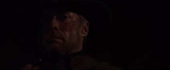 Movie still from “Unforgiven” (1992), directed by Clint Eastwood – A person wearing a cowboy hat; Close Up shot, Low angle