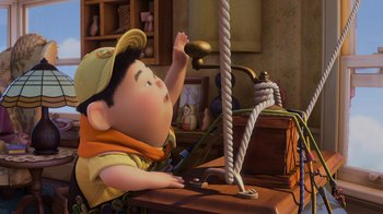Movie still from “Up” (2009), directed by Bob Peterson – An animated boy is sitting at a desk; Medium shot, Overhead angle