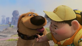 Movie still from “Up” (2009), directed by Bob Peterson – A boy petting a dog's face with his hand; Close Up shot, Over the shoulder angle