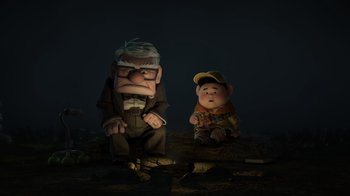 Movie still from “Up” (2009), directed by Bob Peterson – A couple of cartoon characters sitting next to each other on the ground; Wide shot, Low angle