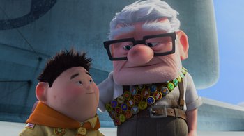Movie still from “Up” (2009), directed by Bob Peterson – An old man and a young boy are standing next to each other; Medium shot, Over the shoulder angle