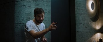 Movie still from “Upgrade” (2018), directed by Leigh Whannell – A man with a goatee is pointing to the side; Medium shot, Low angle