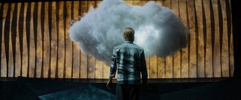 Movie still from “Upgrade” (2018), directed by Leigh Whannell – A man standing in front of a cloud of smoke coming out of a window; Wide shot, Low angle