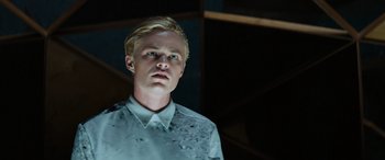 Movie still from “Upgrade” (2018), directed by Leigh Whannell – A man with blonde hair wearing a white shirt; Close Up shot, Low angle