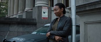 Movie still from “Upgrade” (2018), directed by Leigh Whannell – A woman standing next to a car on the side of the street; Medium shot, Low angle