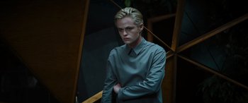 Movie still from “Upgrade” (2018), directed by Leigh Whannell – A man standing on a staircase in a room; Medium shot, Low angle