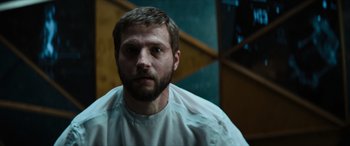 Movie still from “Upgrade” (2018), directed by Leigh Whannell – A man with a beard is standing in front of a mirror; Close Up shot, Low angle