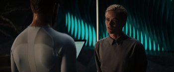 Movie still from “Upgrade” (2018), directed by Leigh Whannell – A man standing next to another man in front of a mirror; Medium shot, Over the shoulder angle