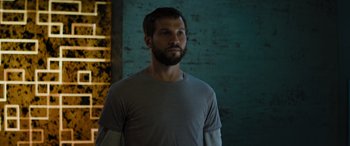 Movie still from “Upgrade” (2018), directed by Leigh Whannell – A man with a beard is standing in a room; Close Up shot, Low angle